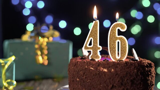 Number forty six birthday candle on sweet cake on the table, 46th birthday. Fire from the lighter, blow out the holiday candle.