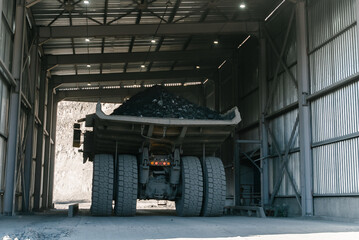 A dump truck loaded with ore passes through the weighing room.	