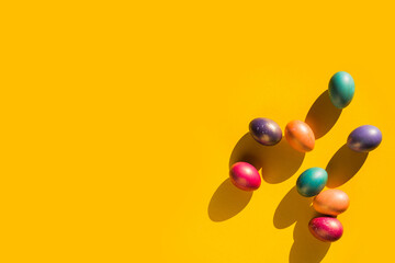 Happy Easter holiday concept. Set of handmade colorful eggs isolated on yellow background with shadow. Simple trendy minimal composition, flat lay, top view, copy space, place for text, banner