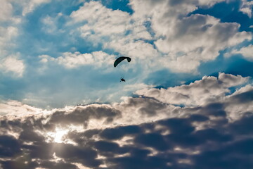 Paraglider on the background of a sunset sky with clouds in summer