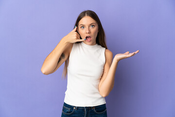 Young Lithuanian woman isolated on purple background making phone gesture and doubting
