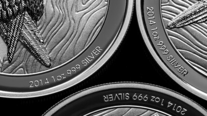 Close up of  Silver Bullion Coin on a black mirror background
