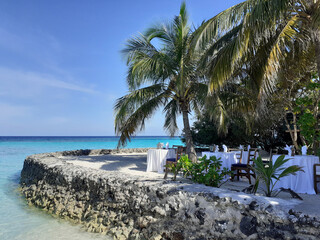 Dinner set-up on the oceanfront terrace. Summer vacation on a Maldives paradise tropical island.