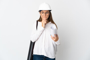 Young Lithuanian architect woman with helmet and holding blueprints isolated on white background having doubts and thinking