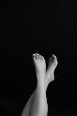 Beautiful female legs, feet and shin. Close-up of a limb on a dark background. Soft focus...