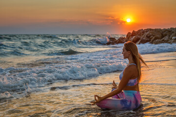 Woman sitting in a lotus position on the beach