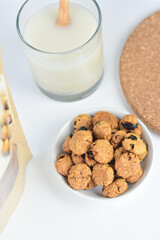 vegan oatmeal cookies with milk in a white bowl