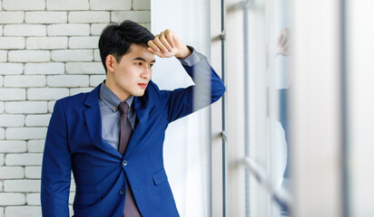 Portrait studio shot Asian handsome professional successful male businessman entrepreneur in formal blue suit necktie standing smiling look at camera on white brick wall background near office window