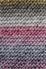 knitting backdrop of hand knit wool fabric in colours of grey and pink 