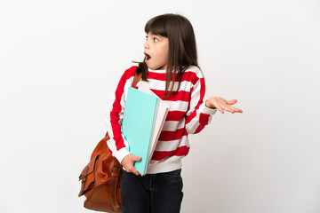 Fototapeta premium Little student girl isolated on white background with surprise expression while looking side
