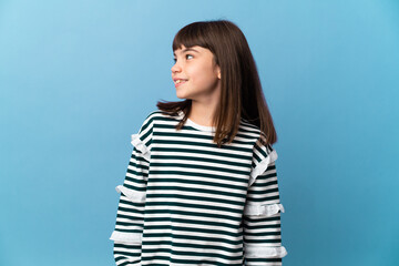 Little girl over isolated background looking to the side and smiling