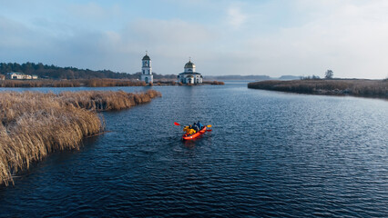 Aerial view of the old Church of the Transfiguration with a red kayak on the island of the Kanev reservoir, the flooded village of Gusintsy, Rzhishchev, Ukraine.