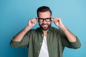 Photo of cheerful positive guy shiny beaming smile wear eyeglasses green shirt isolated blue color background