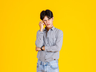 Studio shot of millennial Asian thoughtful doubtful curious male fashion model in stylish...