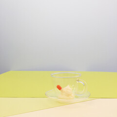 투명하고 작은 티컵 안에 든 알략과 크림하나, 화장품 제형 촬영, 비타민 크림 / In a transparent and small tea cup, there's a glue and a cream, a cosmetic shoot, a vitamin cream