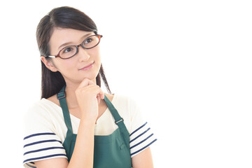 考えるエプロン姿の女性