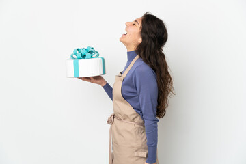 Pastry Russian chef holding a big cake isolated on white background laughing in lateral position