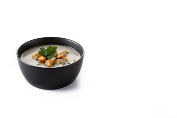 Garlic soup topped with croutons in black bowl isolated on white background