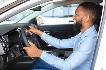 Buying Auto. Black Man Sitting Inside Of Car And Holding Steering Wheel