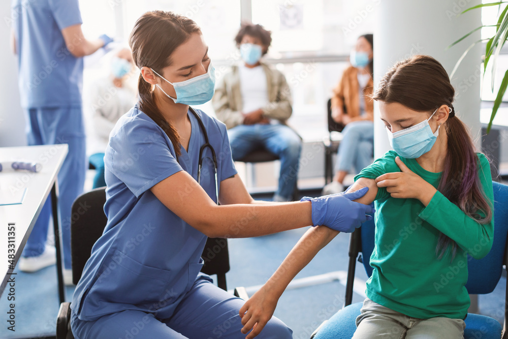 Wall mural teen getting vaccinated against covid, nurse applying adhesive bandage