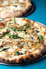Italian fast food. Delicious hot pizza served on a metal platter over blue background.