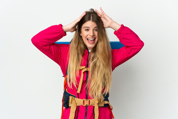 Fototapeta premium Young mountaineer woman with a big backpack over isolated background with surprise expression