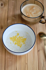 Rice milk porridge. Side view, wooden background.