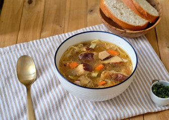 Mushroom soup with noodles. Side view, wooden background