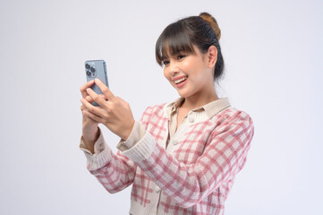 Fototapeta premium Young beautiful woman using smart phone isolated on white background