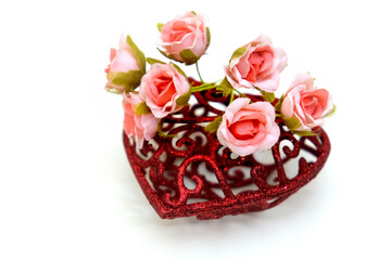 Artificial flower and red heart on white background, wedding interior detail close up