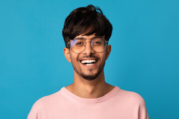 Closeup portrait of cheerful indian guy smiling at camera