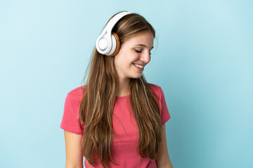 Young caucasian woman isolated on blue background listening music