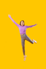 Fototapeta na wymiar Photo of young joyful sport woman jumping over yellow background.
