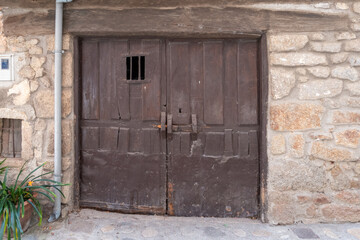 Entrance to an old stable with stone walls with an old two-leaf door