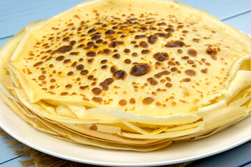 pile of pancakes in a plate on a blue background