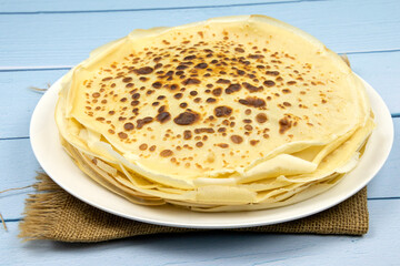 pile of pancakes in a plate on a blue background