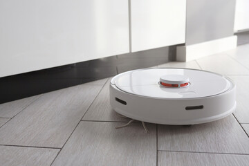 Hoovering floor with modern robotic vacuum cleaner indoors, closeup
