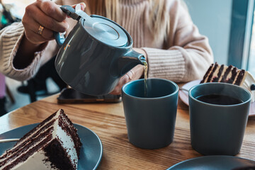 A girl in a cafe pours tea into cups. Beautiful cozy photo