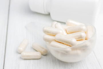 White pills or capsules in a plastic spoon, medication treatment, alternative medicine, close-up view