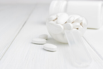 Fototapeta na wymiar White pills in a plastic spoon, medication treatment, close-up view