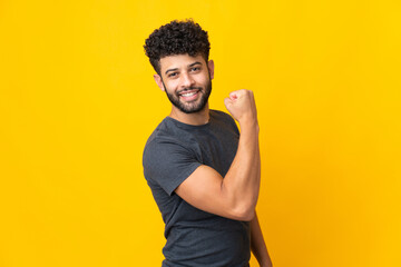 Young Moroccan man isolated on yellow background doing strong gesture - obrazy, fototapety, plakaty