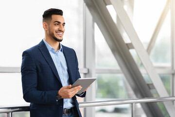 Fototapeta premium Portrait Of Handsome Middle Eastern Businessman Using Digital Tablet At Airport