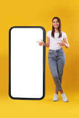 Woman pointing at big white empty smartphone screen, mock-up