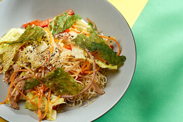 Asian salad with carrots, cabbage and sesame in a plate with bright backgrounds. Selective focus, hard light
