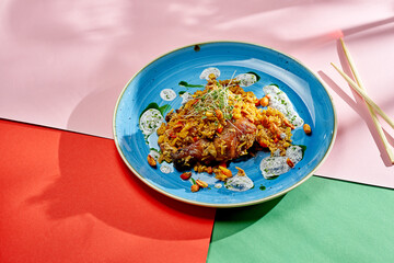 Asian wok rice with chicken, peanuts and vegetables in a plate on bright backgrounds. Selective focus, hard light