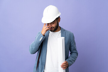 Young architect Moroccan man with helmet and holding blueprints over isolated background laughing