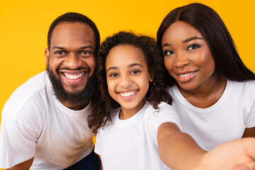 Portrait of happy black family taking selfie together at studio