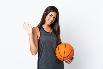 Young brazilian woman playing basketball isolated on white background saluting with hand with happy expression