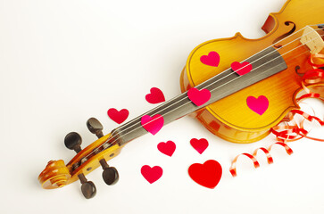 Violin and red hearts on a white background. Symbol of love.