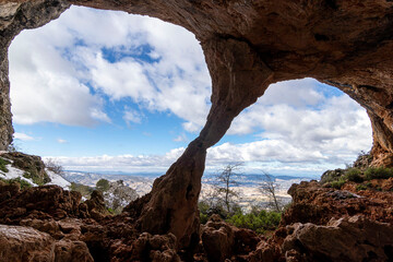 Bolumini cave from the inside, in the background a snowy landscape with blue sky. Mariola natural...